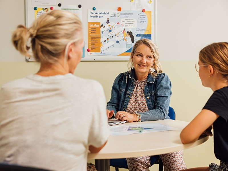 Jeugdverpleegkundige heeft gesprek met kind uit groep 7 en moeder